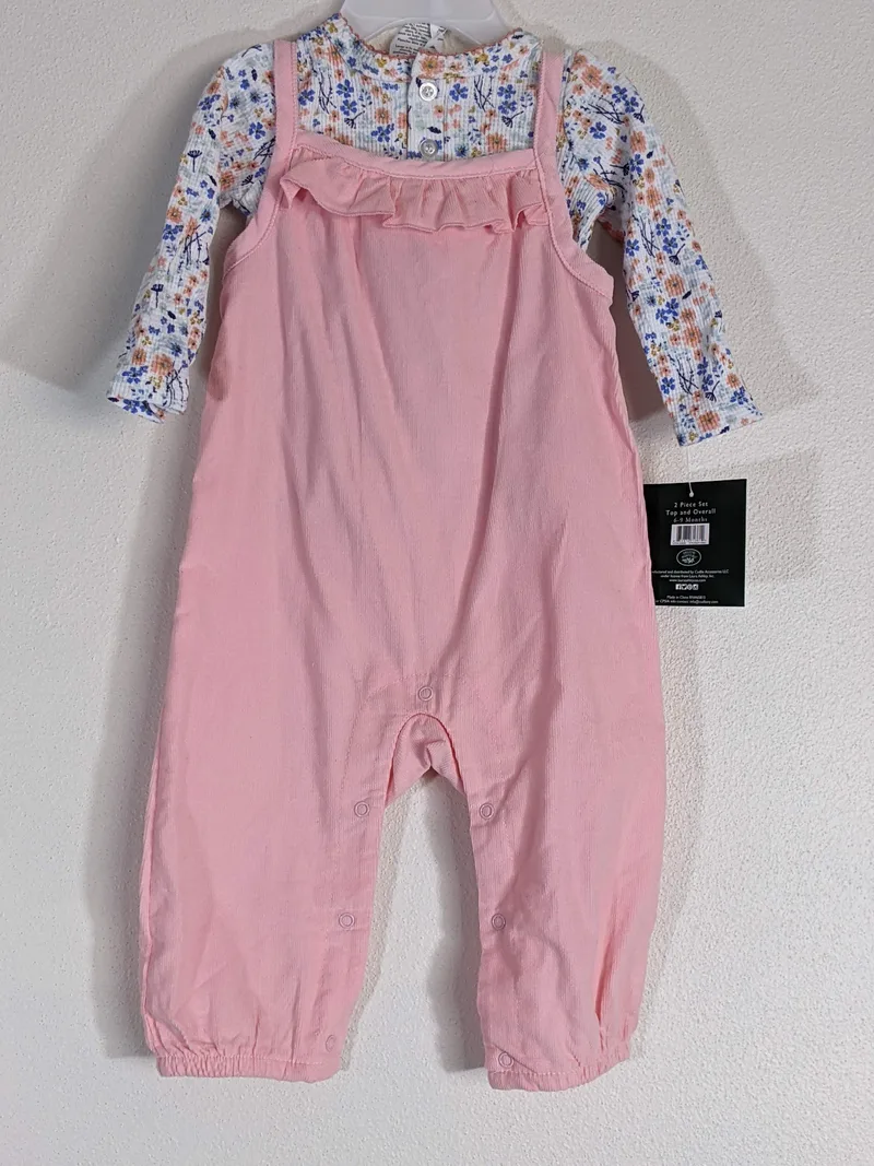 A pink overall infant outfit with a flower undershirt.