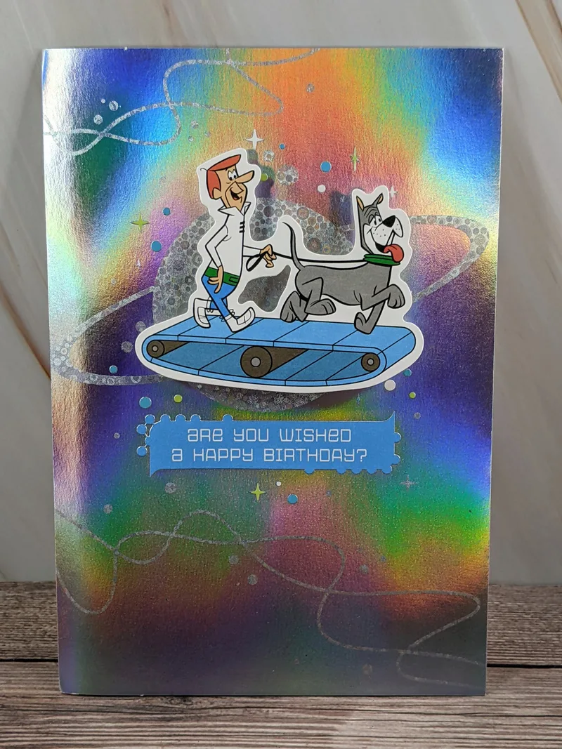 A shiny silver birthday card with a retro themed Jetsons cartoon image on the front cover.