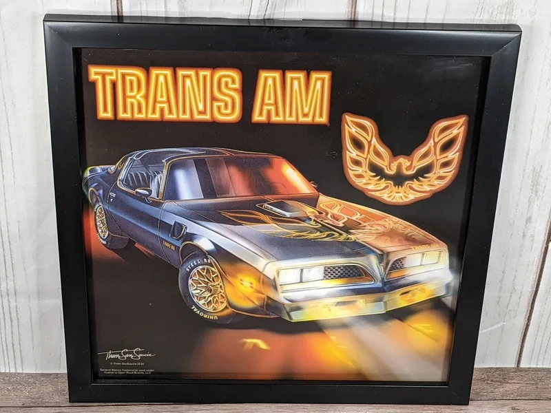 A wall art piece in a black frame that features vivid image-shifting effects of a Trans Am car made by GM.