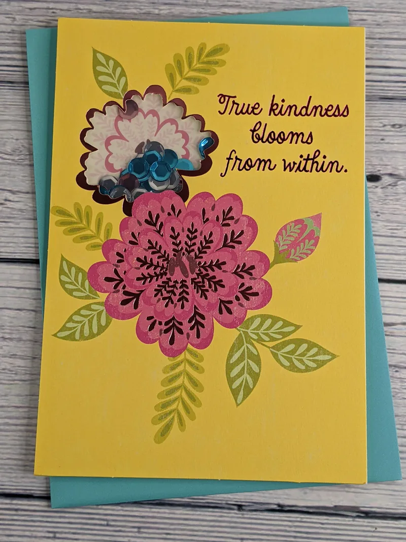 A shaker greeting card with a thank-you message and a floral design on a yellow background.