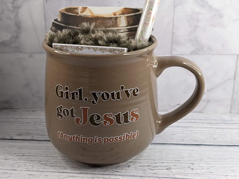 A Christian coffee mug with gifts inside.