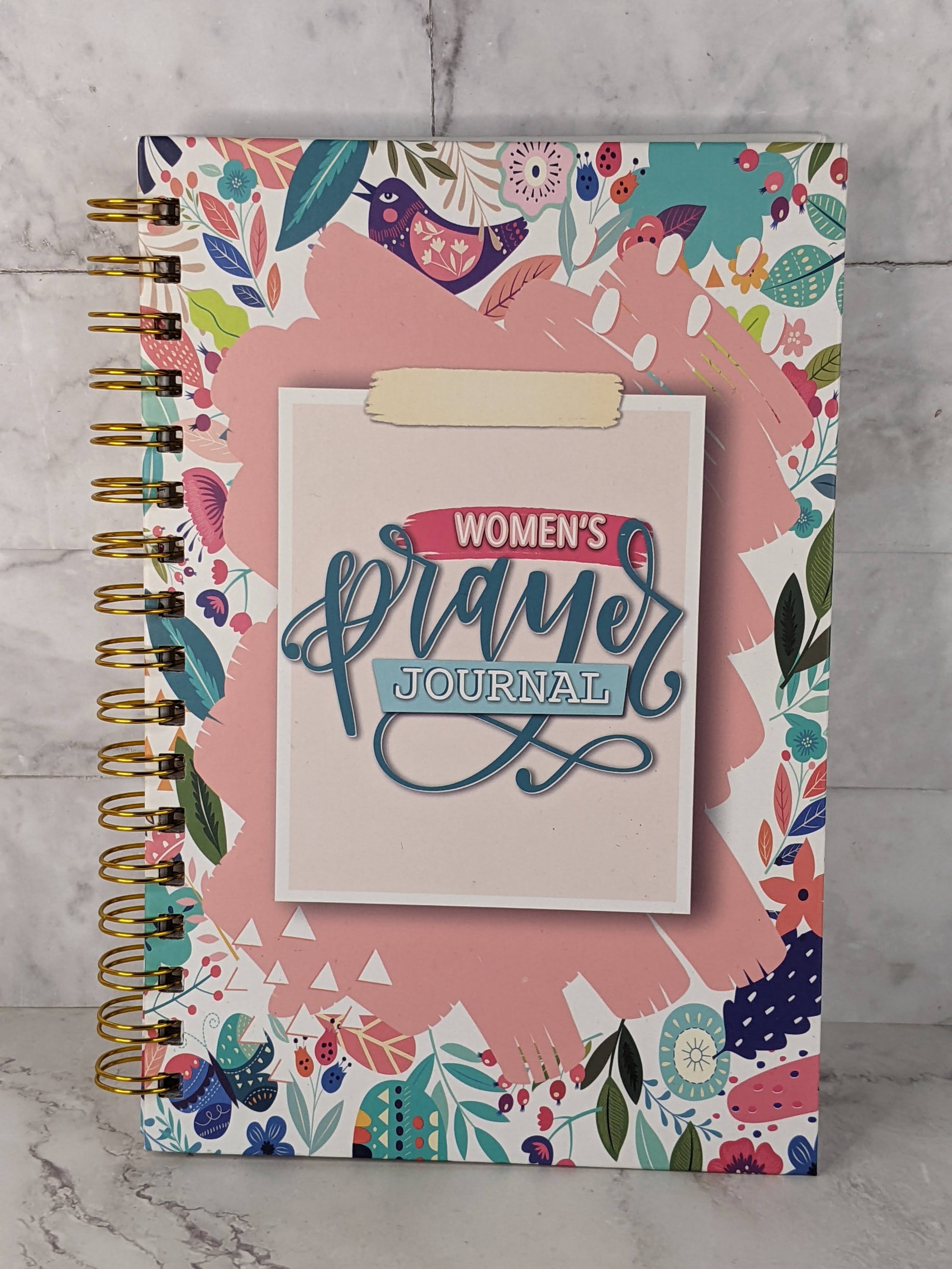 A spiral book religious journal for women, with prompts for prayer themed journal entries.