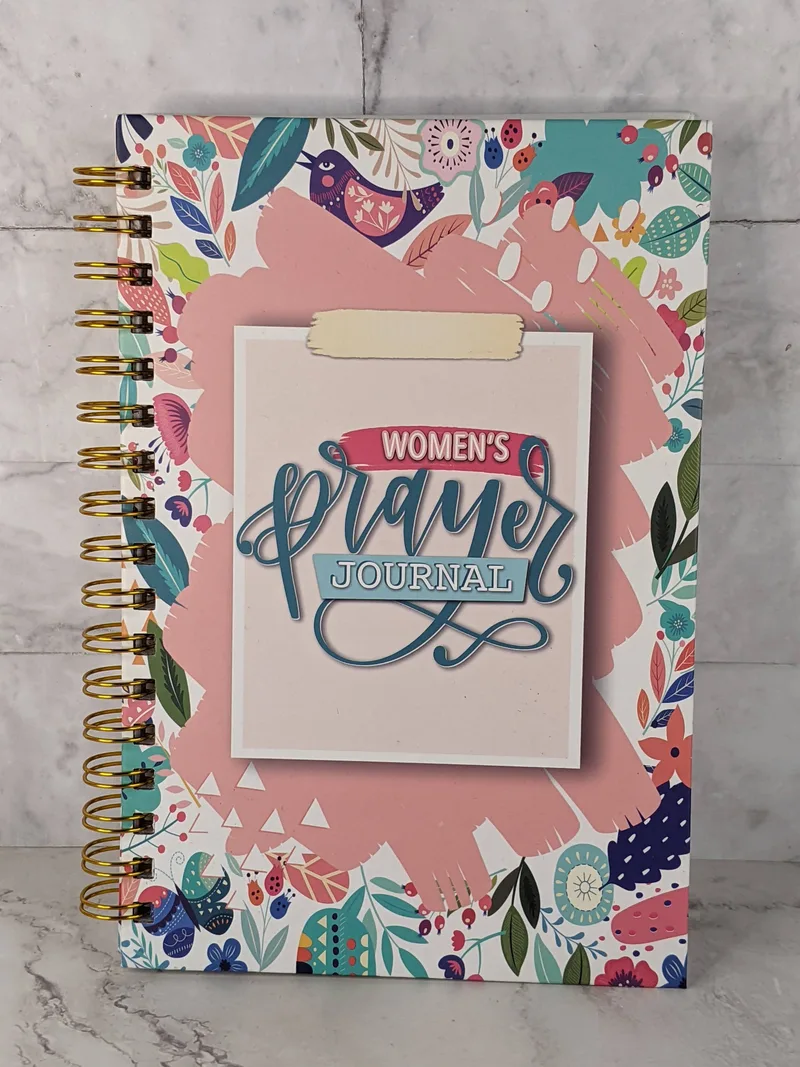 A spiral book religious journal for women, with prompts for prayer themed journal entries.