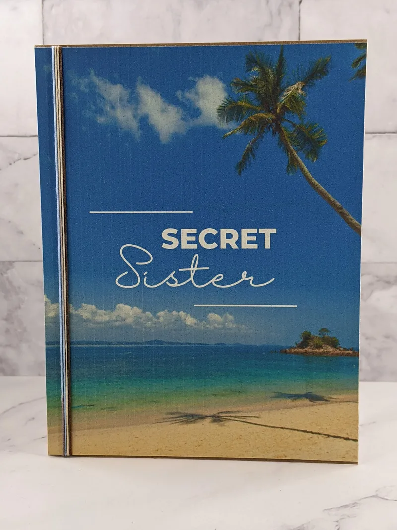 A Secret Sister greeting card with an image of a peaceful beach on the cover.