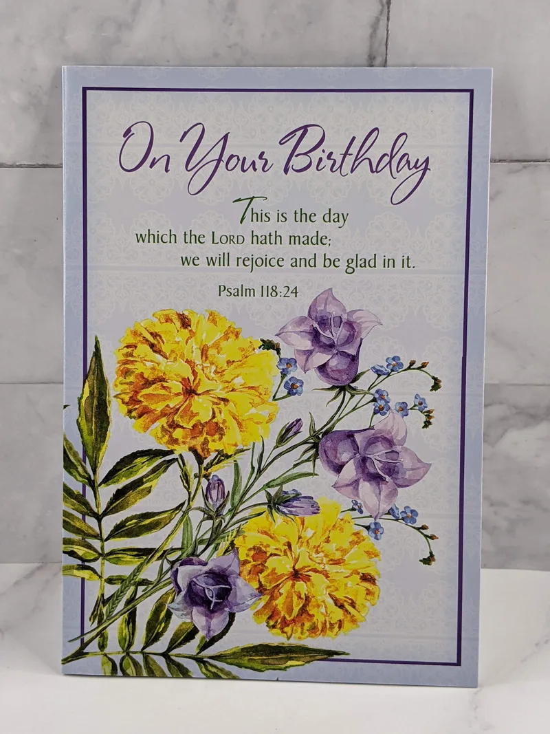 A Secret Sister birthday card with a design of yellow flowers on the cover and a religious message with a Bible verse.
