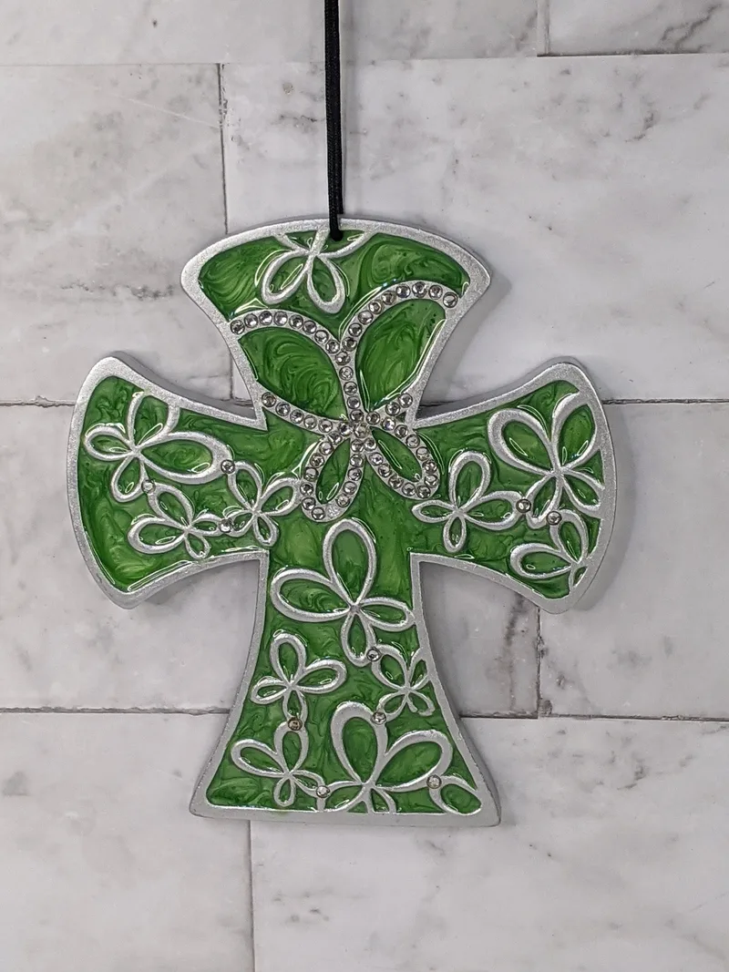 A green wall cross with a silver design of butterflies, and crystal accents.