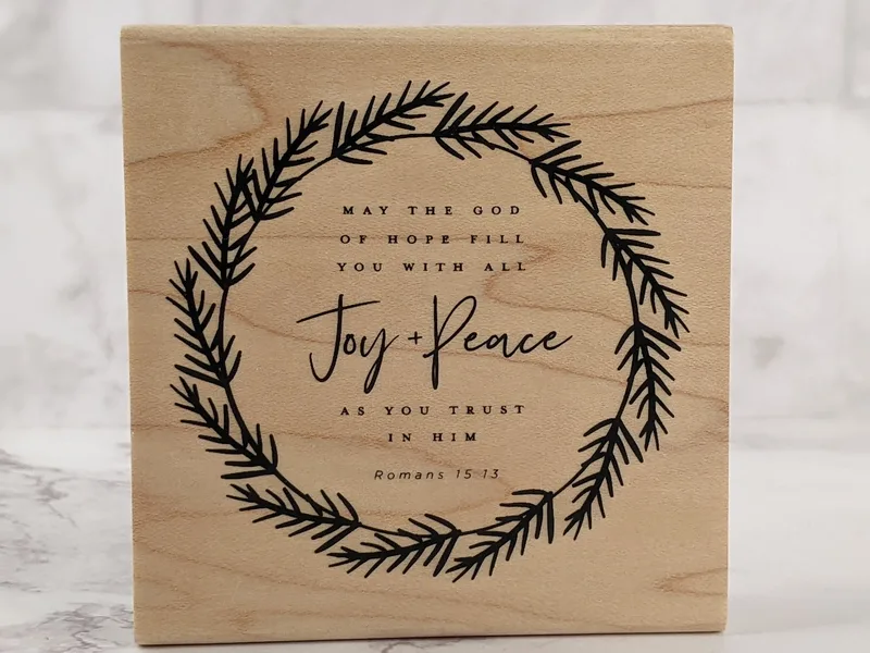 A rubber stamp with a Bible verse about the God of Hope.