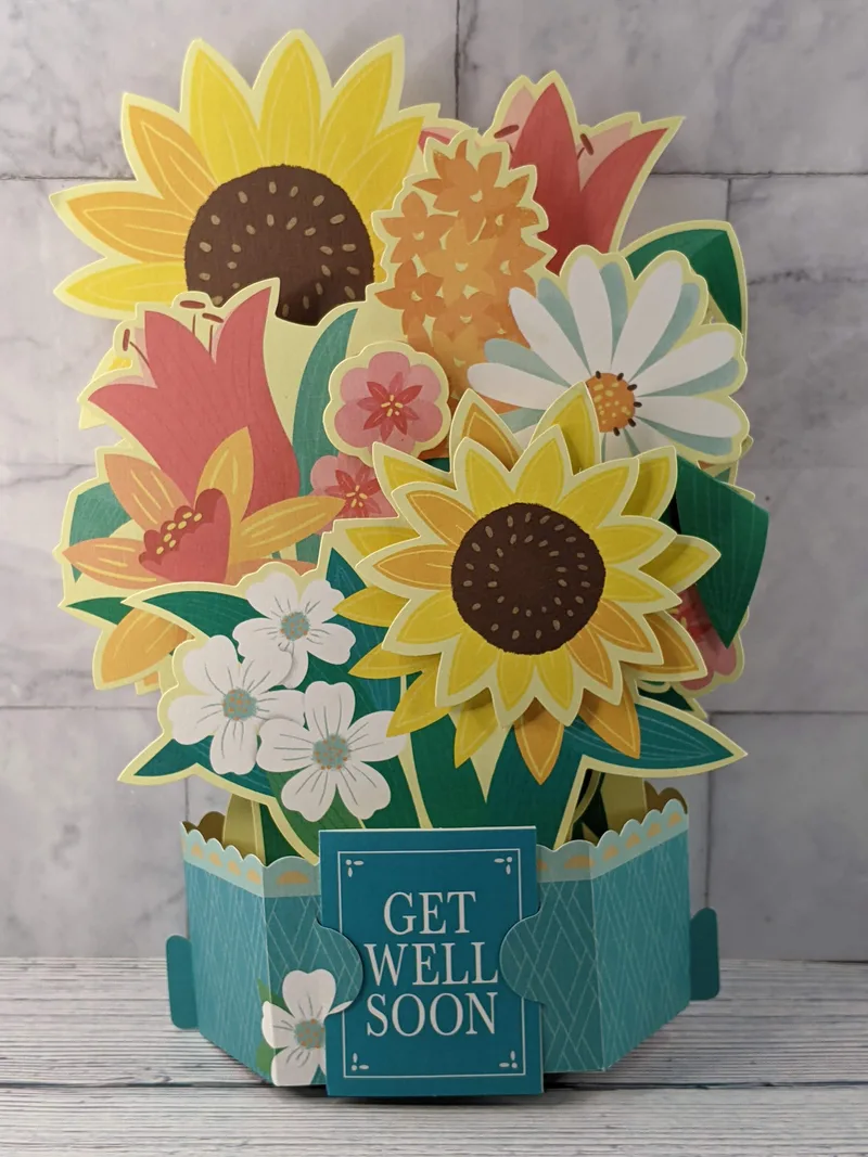 A pop-up paper sunflower bouquet with a mini get-well card.
