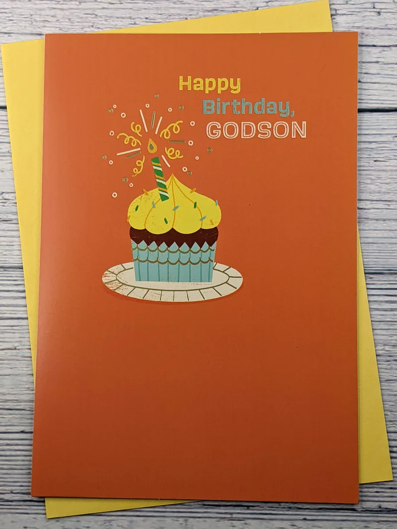 An orange birthday card for a godson with an image of a cupcake.