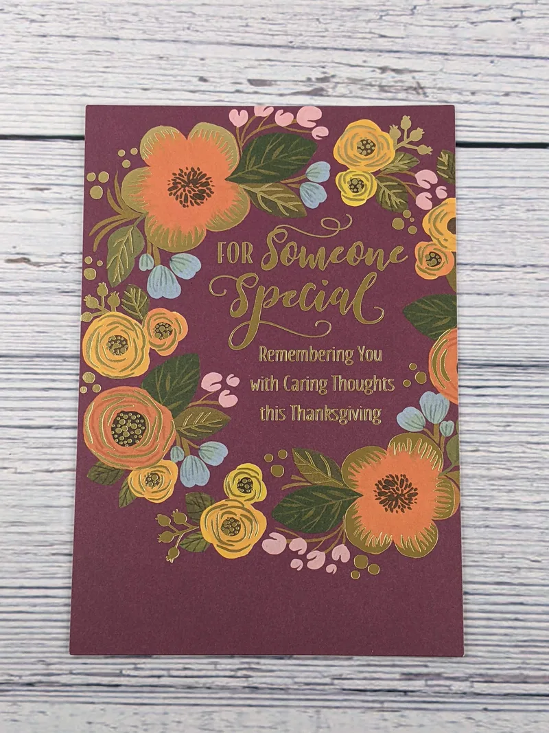 A burgundy Thanksgiving card with a religious message and an image of a floral wreath.