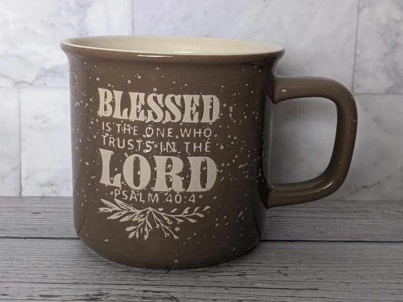 A tan and brown ceramic mug with a Bible verse, Psalm 40:4.