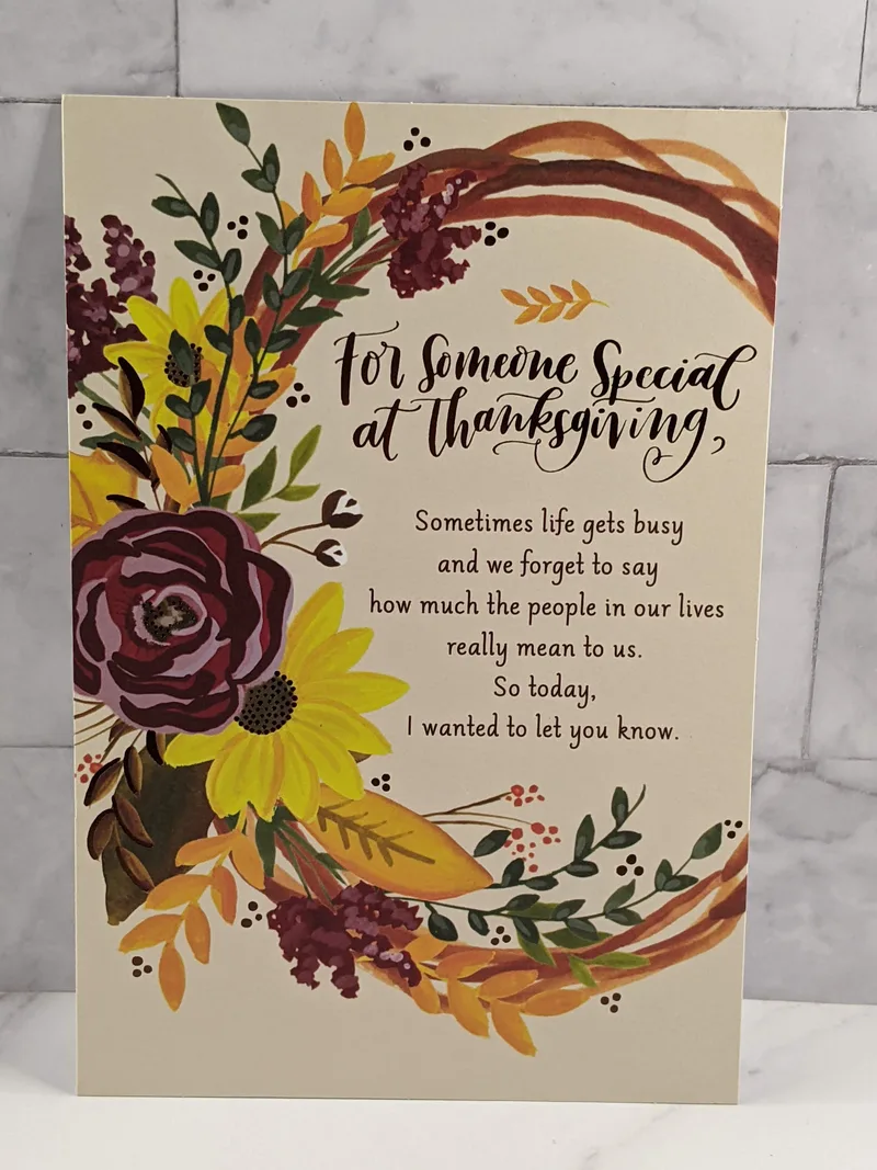 A Thanksgiving card with a religious sentiment and an image of a wreath with burgundy and yellow flowers.