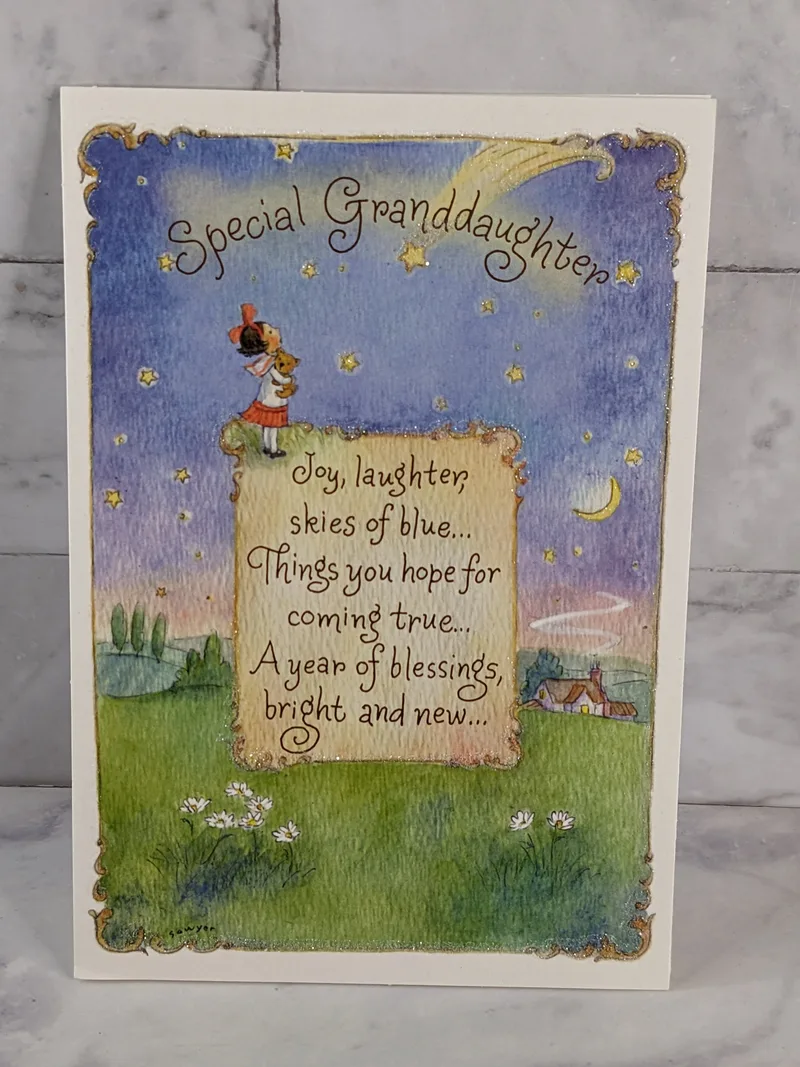 A Christian birthday greeting card for a granddaughter, with a religious message and an image of a girl hugging a teddy bear.