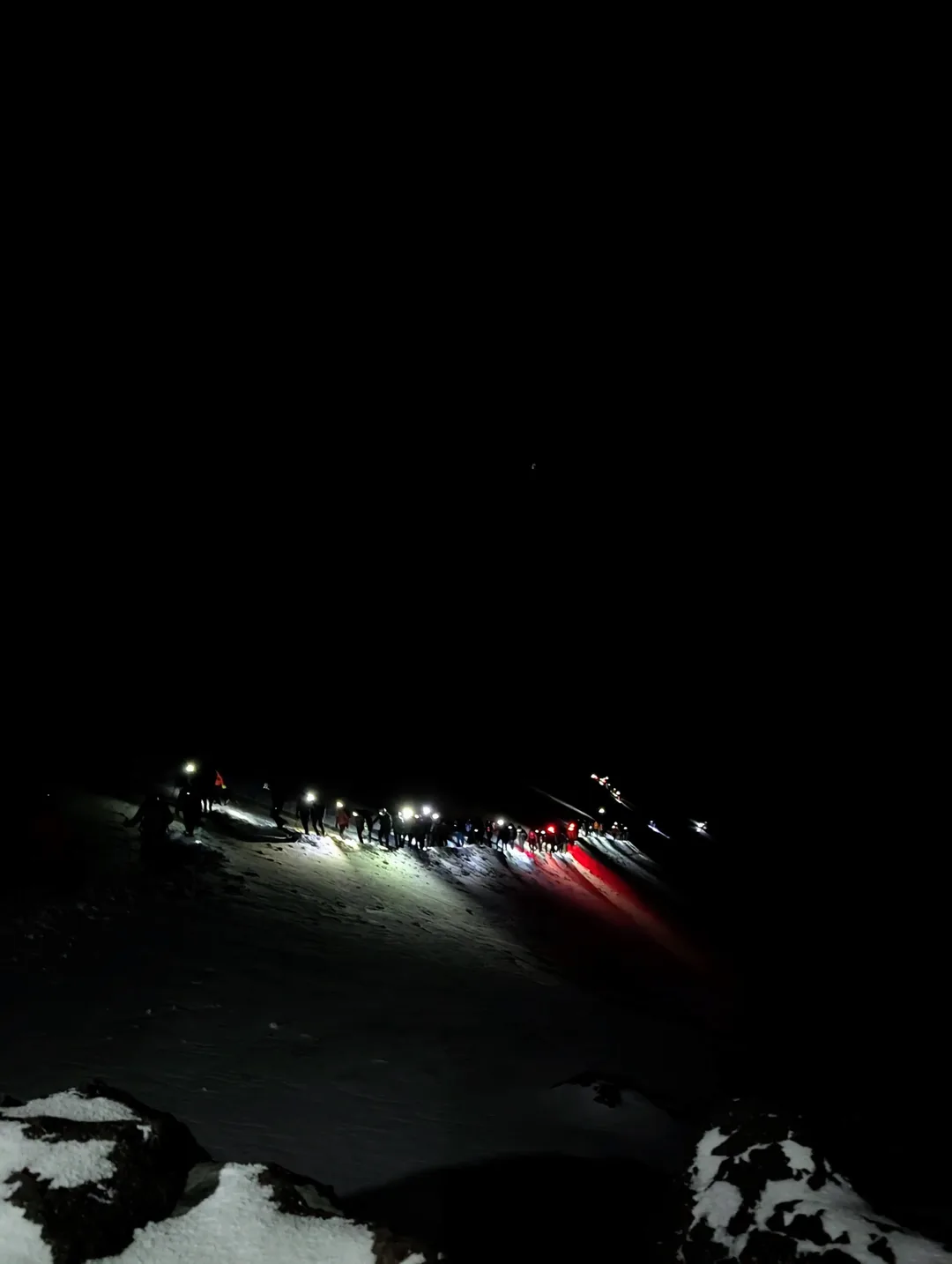 A trail of head torches in the dark.