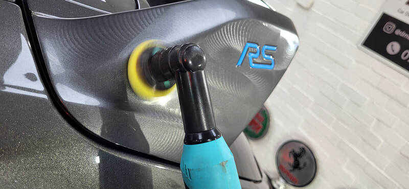 Machine polishing Ford Focus RS spoiler during minor paint correction at DMD Car Detailing in Paisley