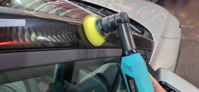 Gloss black panel being machine polished in Paisley at DMD Car Detailing