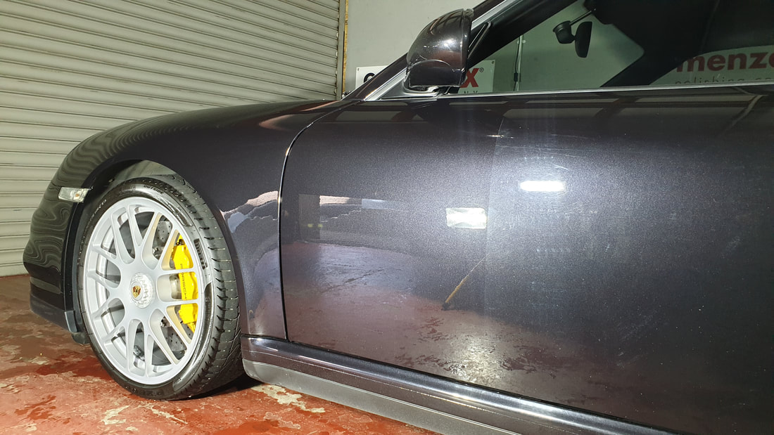 Porsche 911 during machine polishing showing the difference on one section of door