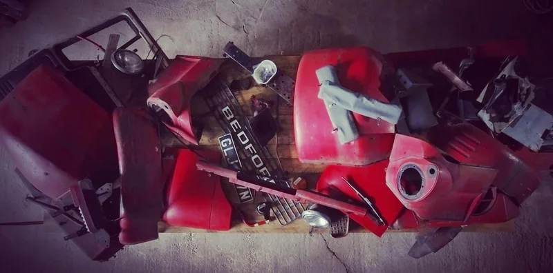 Aerial view of a workbench piled up with the parts of a Bedford truck