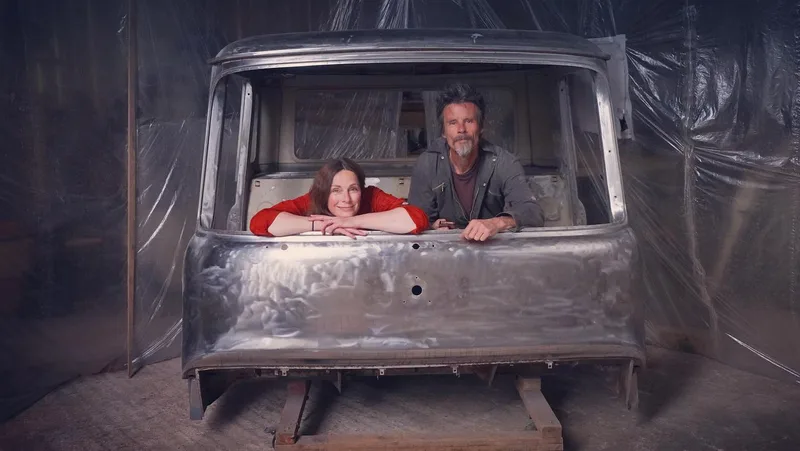 Man and woman with a Bedford cab in bare metal