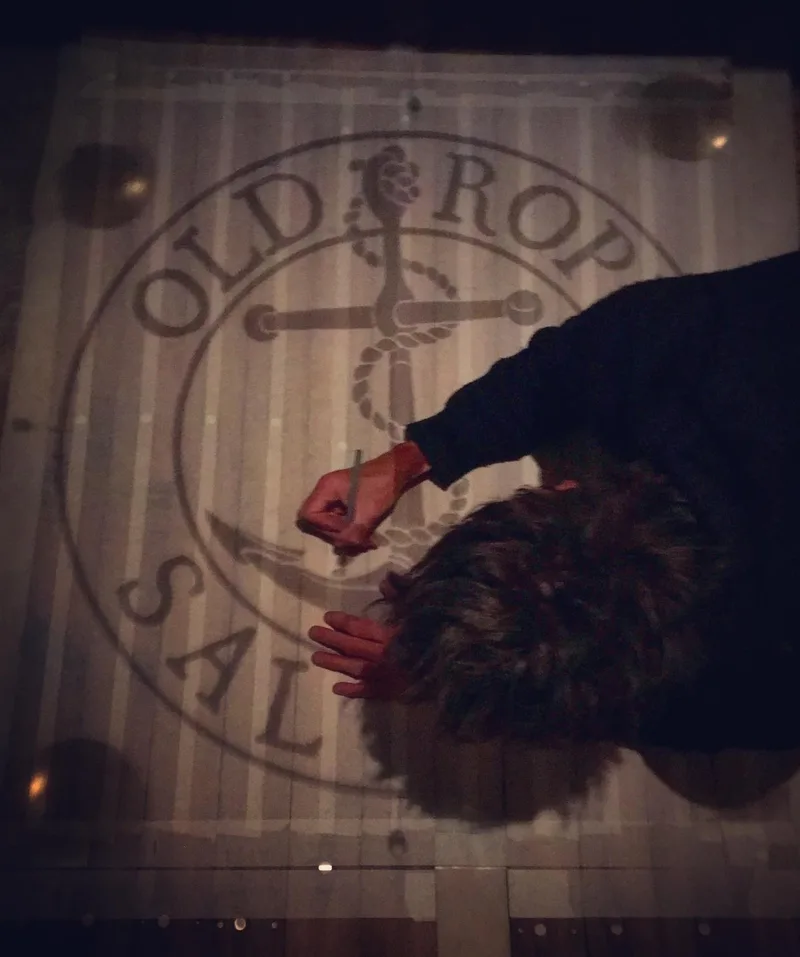 Man drawing old rope salvage logo on to wooden boards