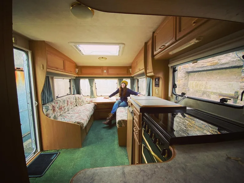 Woman in the lounge of an old caravan