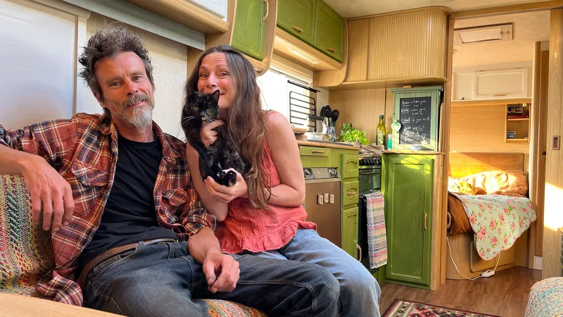 Man, woman and cat in a newly renovated caravan