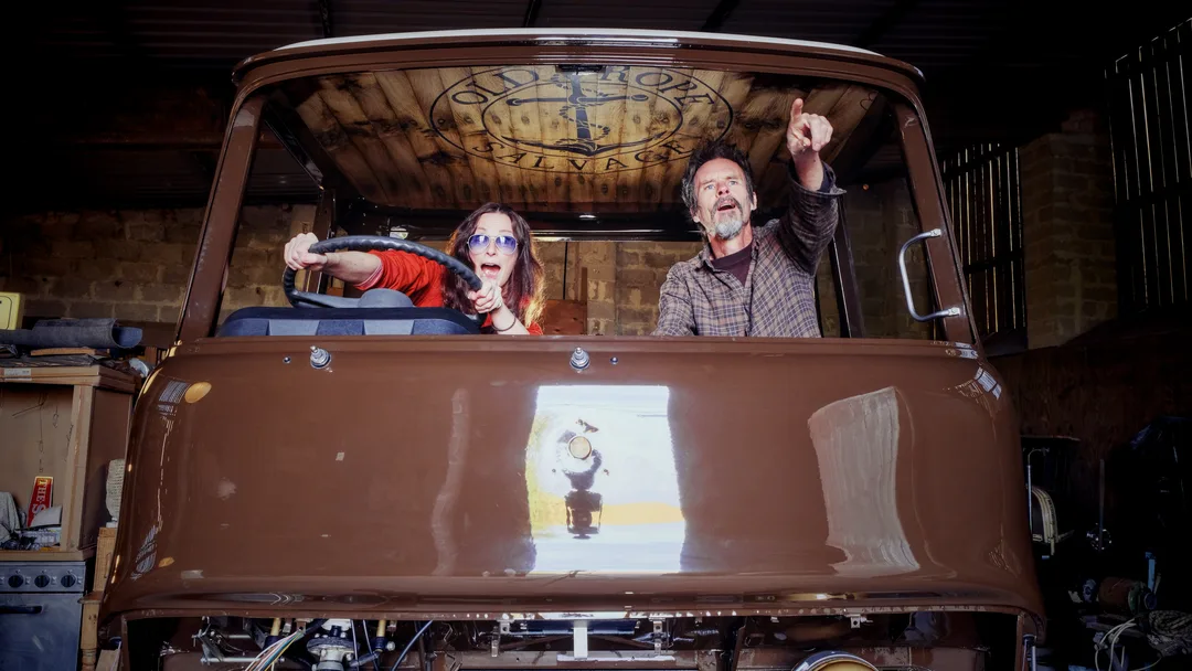 Man and woman inside the restored cab of a 1975 Bedford truck