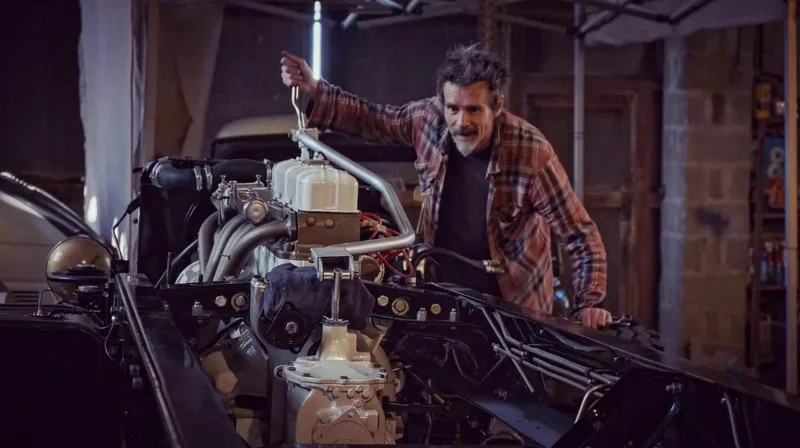 Man adjusting a restored gearbox in a 1970s restored Bedford truck