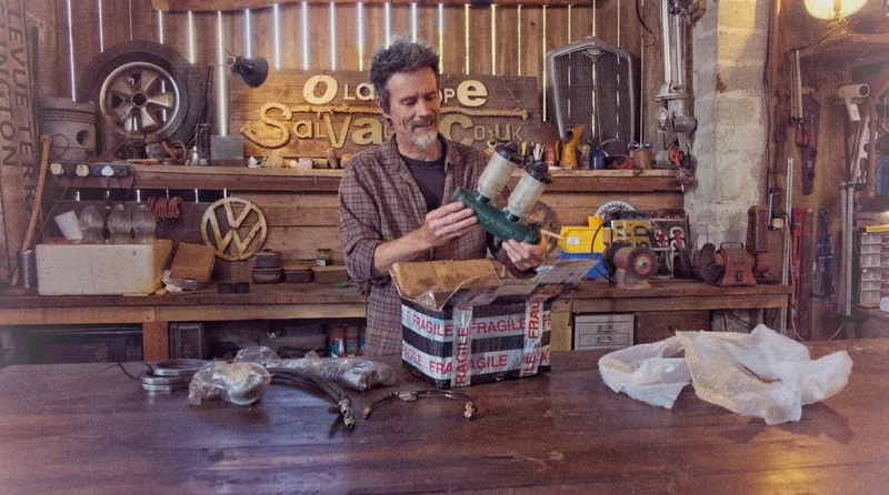 Man in workshop unpacking a master cylinder for a Bedford truck