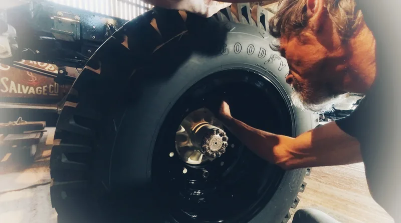Man fitting a large tyre on to a Bedford truck