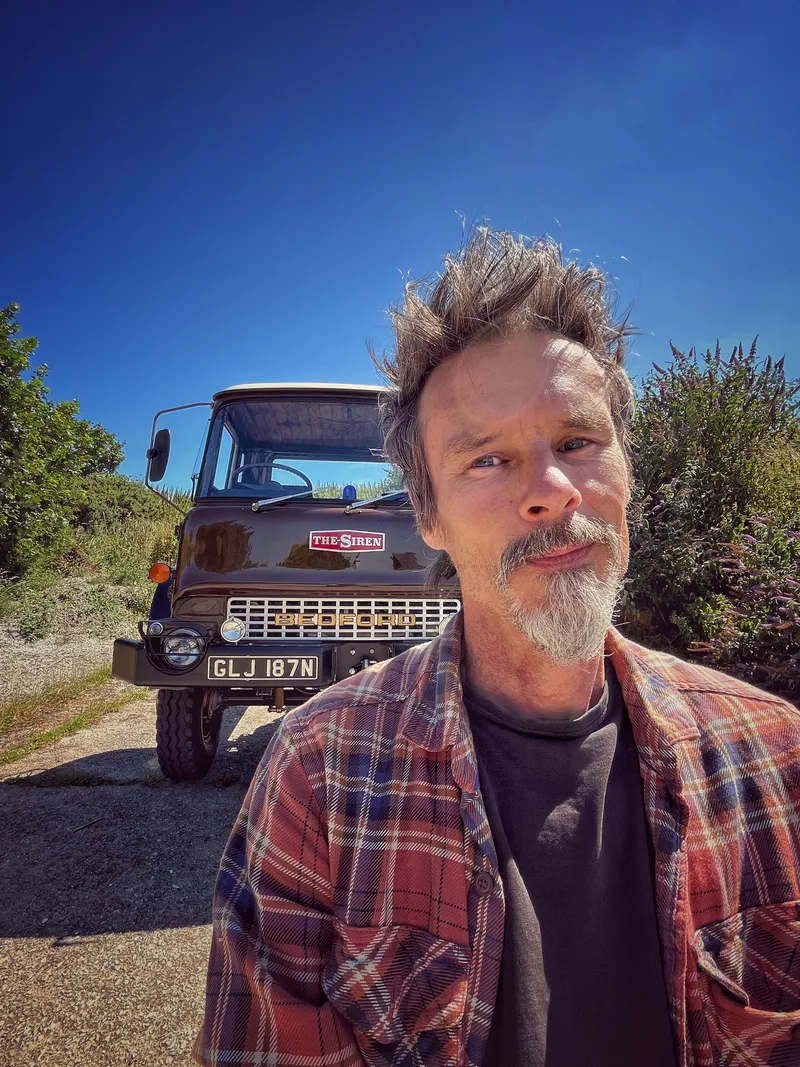 Man standing outside in front of a Bedford truck